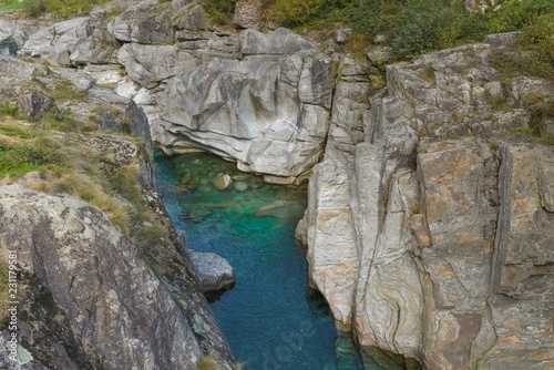 Acqua blu verde scorre tra le alte rocce grigie del fiume