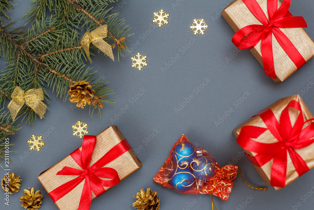 Gift boxes, fir tree branches with cones on gray background Gift boxes, fir tree branches with cones on gray background