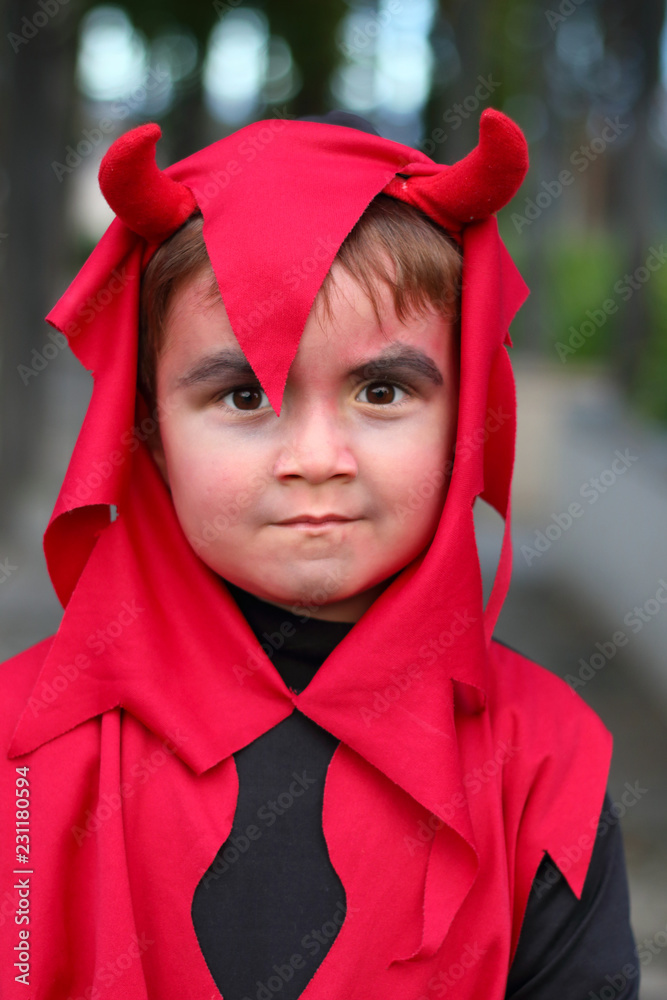 niño disfrazado de demonio con cuernos con cara de malo Stock Photo | Adobe  Stock