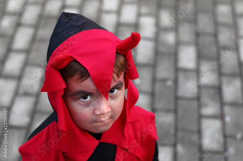 niño disfrazado de demonio con cuernos con cara de malo photo