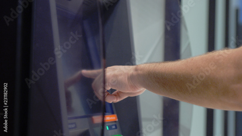 ATM Banking Hand Enter Pin Code In Cash Machine. Male hand typing personal pin code in a ATM cash machine. close up shot