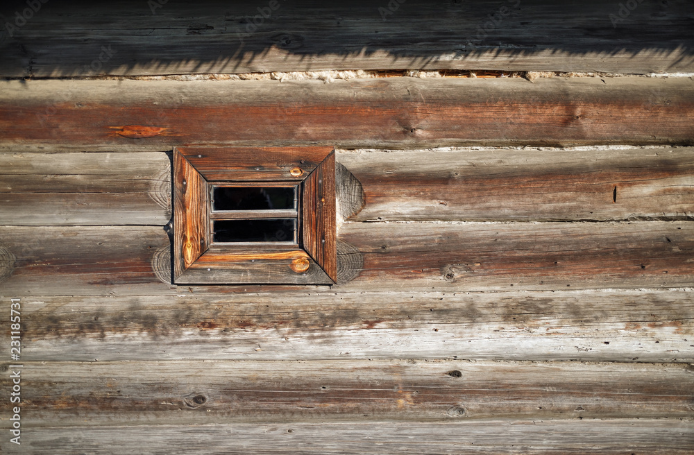 Small wood window in the wall of old wooden log house. Space for text. Small wood window in the wall of old wooden log house. Space for text.