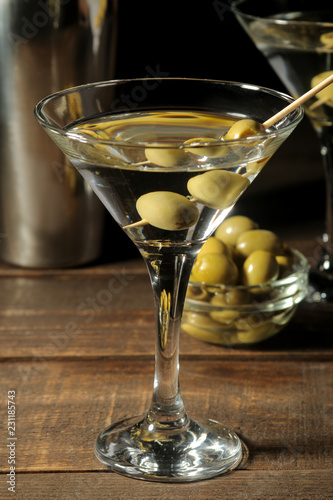 Wallpaper Mural Martini in a glass wineglass with green olives on a skewer on a brown wooden table. cocktails. bar Torontodigital.ca