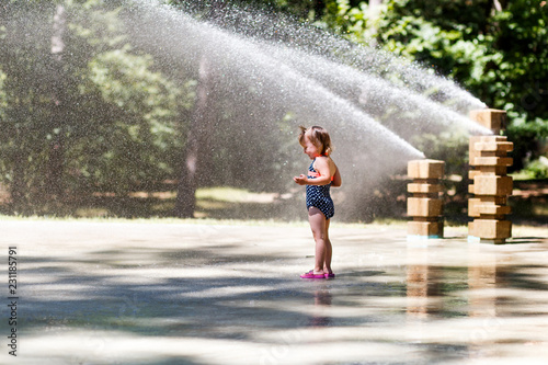 a girl having fun in the fountain on a hot summer day. family and love concept