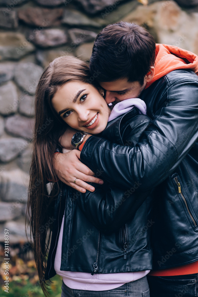 Romantic meeting of a young couple against a stone wall.
Romantic meeting of a young couple against a stone wall.
