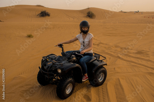 desert Quad Biking. Young girl in helmet driving a Quad bike