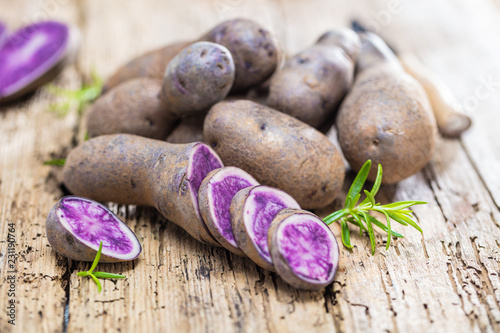 Vitolette noir or purple potato. On a wooden background. photo