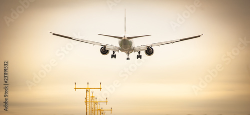 Commercial airplane landing at sunset. Runway approach lights. Concept for transport,transportation,travel,aviation,vacation,business travel,freedom,reaching destination,speed. Shot at Milan Malpensa © pcruciatti