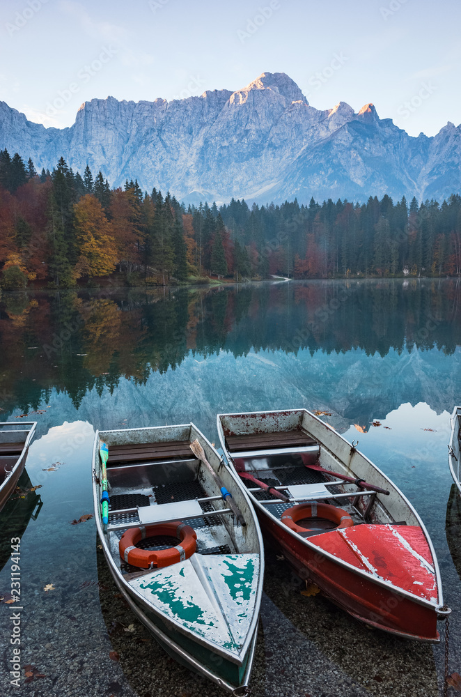 Colorful boats at scenic Fusine Lake in Italian Alps