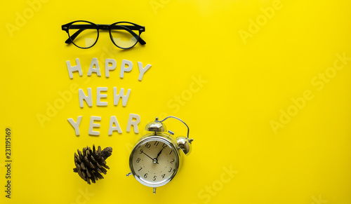 Symbol Celebration Happy new Year with black glasses and vintage o'clock on a yellow paper background .