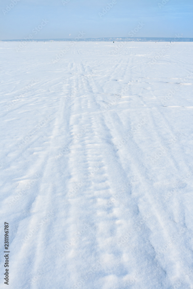 Traces of sledge runners and ski on white freshly fallen snow on winter frozen lake. Traces of sledge runners and ski on white freshly fallen snow on winter frozen lake.