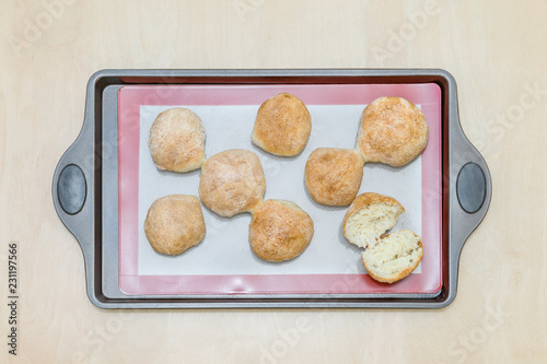 freshly baked buns on a silicone baking mat, on an iron tray