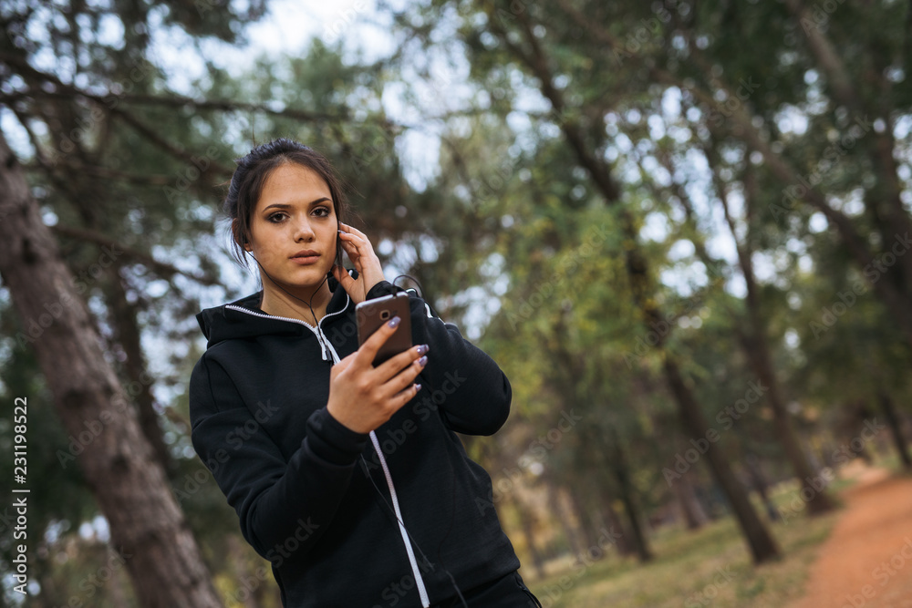 Woman listening to music while exercising in the outdoors