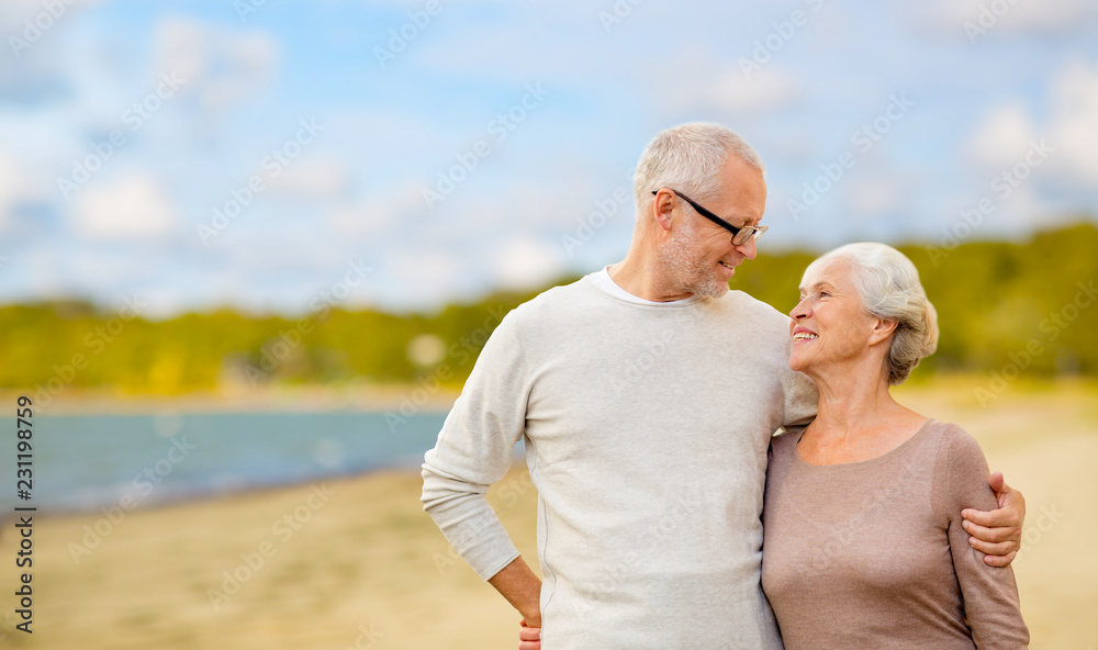 old age, retirement and people concept - happy senior couple hugging over beach background old age, retirement and people concept - happy senior couple hugging over beach background