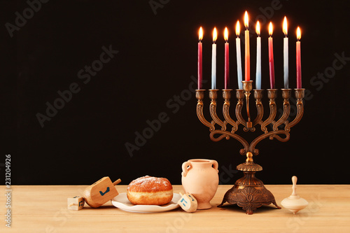 image of jewish holiday Hanukkah background with menorah (traditional candelabra) and burning candles. photo