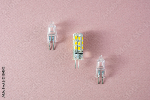 Two halogen and one modern eco LED type arranged diagonally on a pink background- technology shift photo