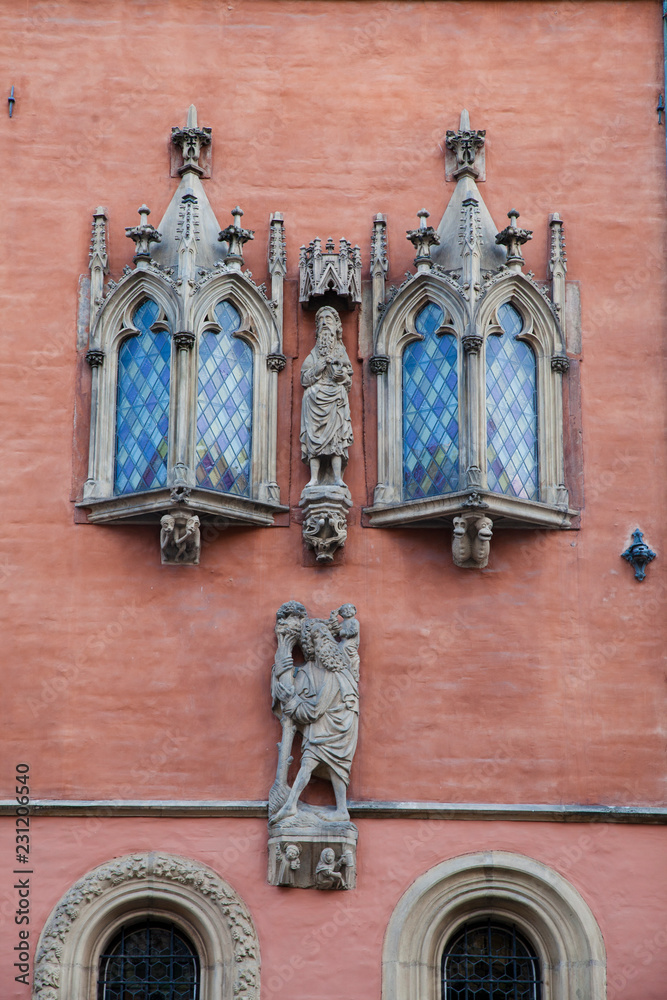 Obraz premium The figures of the inhabitants of Wroclaw and the beautiful windows on the building of the Town Hall of the city Wroclaw