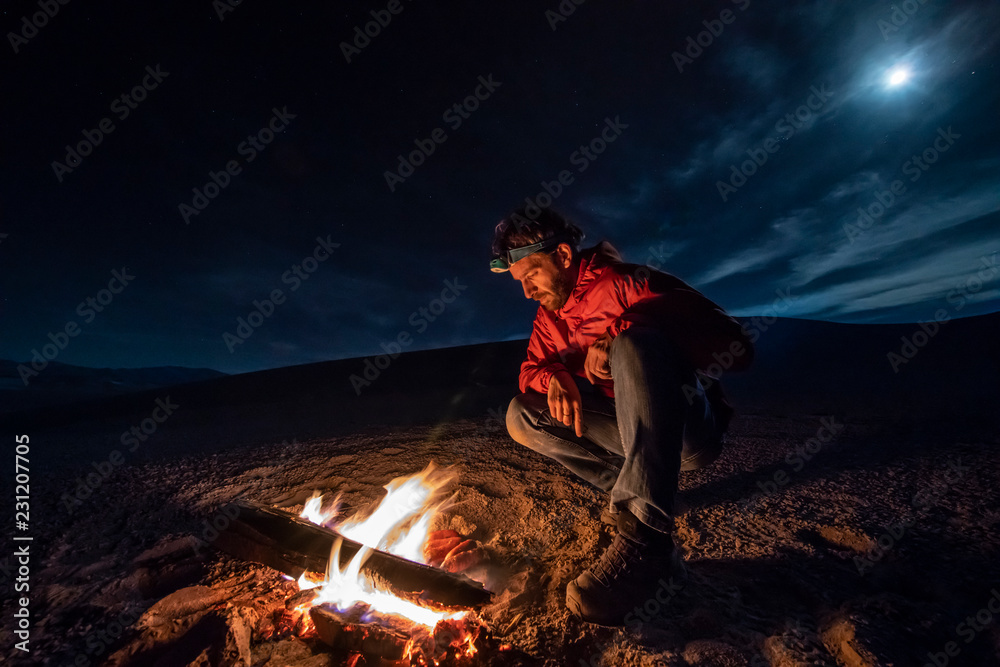 Obraz premium While looking for meteorites at Atacama Desert we made a stop for sleeping in the middle of the amazing Atacama Desert. One man on a camp fire under the full moon light on a starry night. Chile 