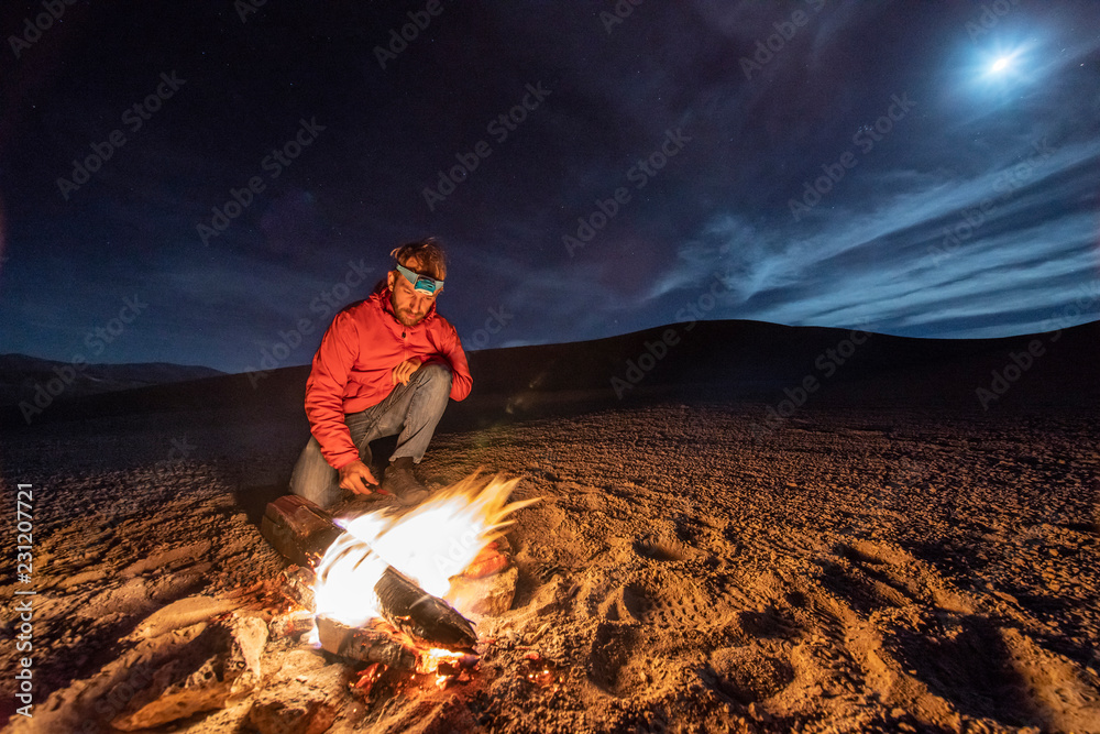 Obraz premium While looking for meteorites at Atacama Desert we made a stop for sleeping in the middle of the amazing Atacama Desert. One man on a camp fire under the full moon light on a starry night. Chile 