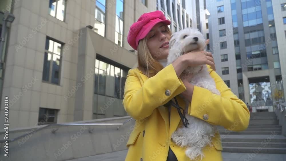 The girl pets her dog at the city The girl pets her dog at the city