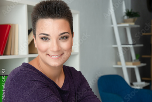 Free Download Beautiful young woman with short hair is smiling. Portrait of a happy woman with short hair and smooth tanned skin in a purple dress. - GFXLoad