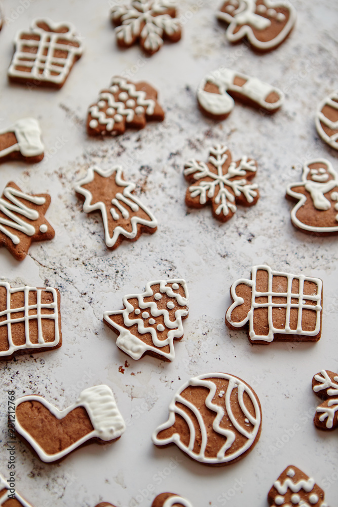 Composition of delicious gingerbread cookies shaped in various Christmas symbols. Placed on white rusty table. Top view. Composition of delicious gingerbread cookies shaped in various Christmas symbols. Placed on white rusty table. Top view.