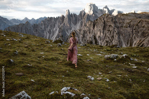 Obraz na plátně woman in long dress in the dolomite mountains in italy