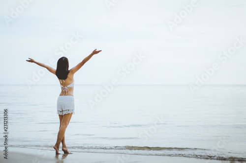 Travel woman walking on beach in sunset