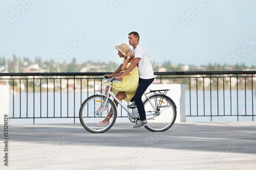 Fototapeta Naklejka Na Ścianę i Meble -  Happy couple riding bicycle outdoors on sunny day