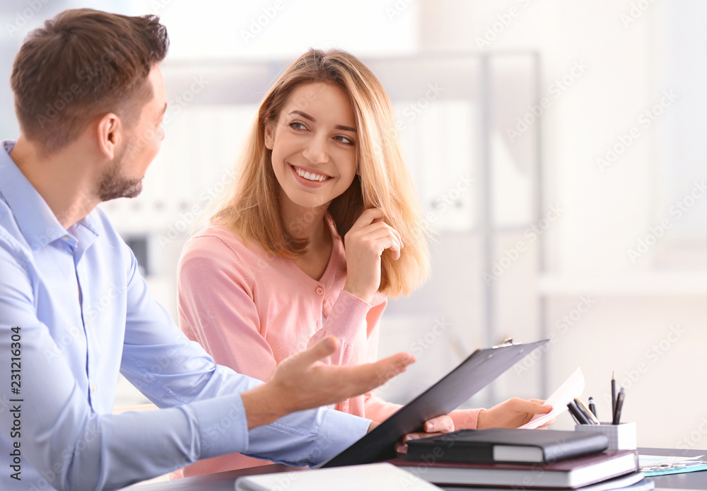 Businessman consulting young woman in office Businessman consulting young woman in office