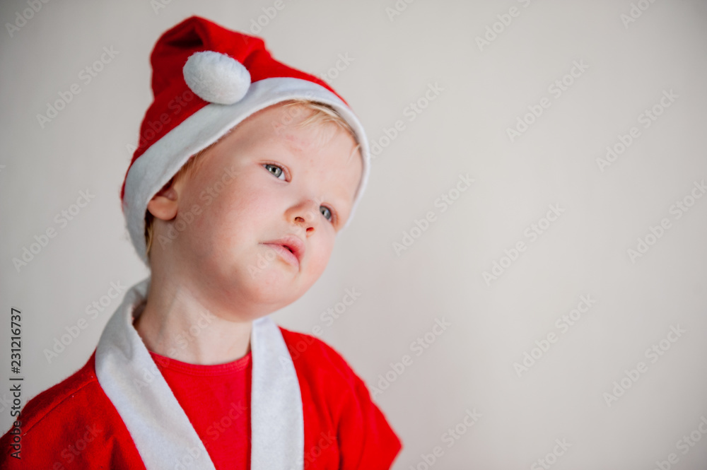 Cute boys dressed in festive costumes of Santa Claus decorate Christmas tree with balls and garlands. Children play and wait for gifts. Christmas Eve Cute boys dressed in festive costumes of Santa Claus decorate Christmas tree with balls and garlands. Children play and wait for gifts. Christmas Eve