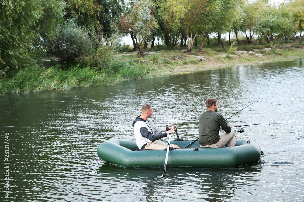 Friends fishing from boat on river. Recreational activity Friends fishing from boat on river. Recreational activity
