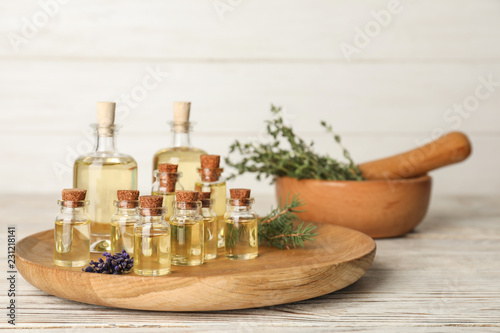 Fototapeta Naklejka Na Ścianę i Meble -  Different essential oils in glass bottles on table