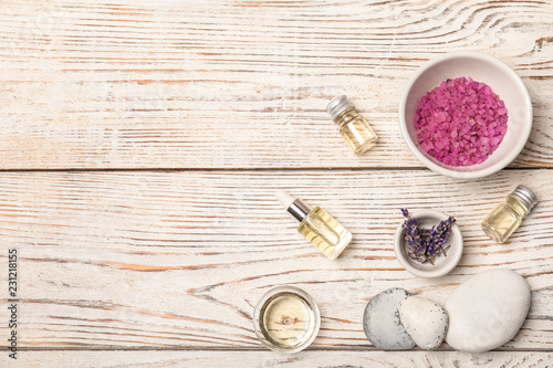 Fototapeta Naklejka Na Ścianę i Meble -  Essential oil, ingredients and space for text on wooden background, flat lay