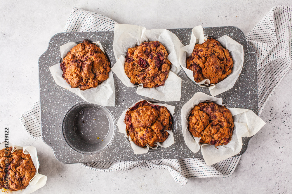 Healthy vegan berry muffins in a baking dish on a white background.