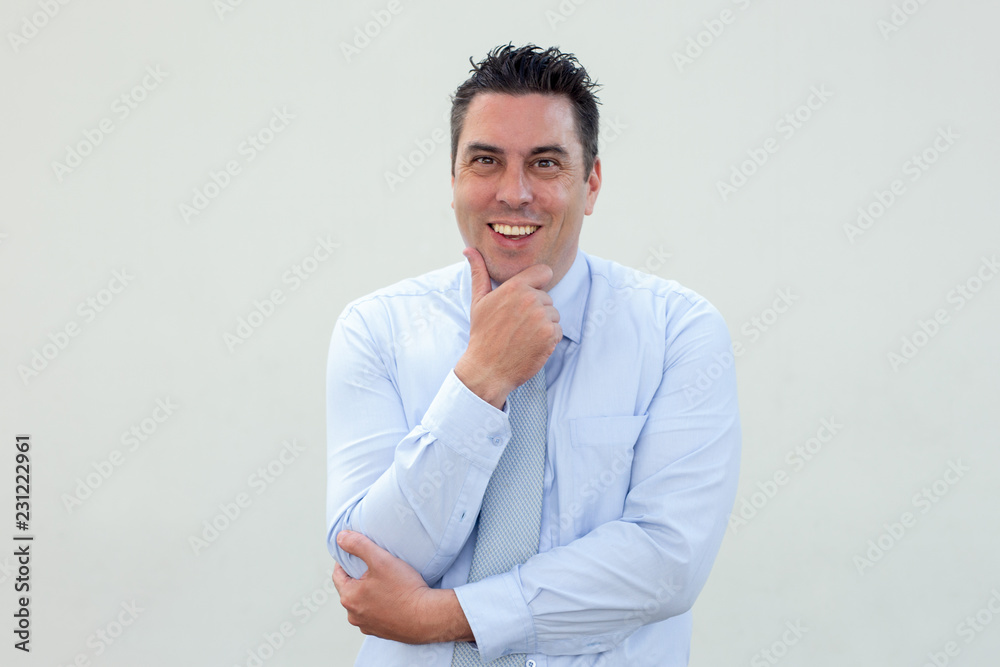 Cheerful enterprising businessman looking at camera. Smiling middle-aged man rubbing chin while having brilliant idea. Manager concept Cheerful enterprising businessman looking at camera. Smiling middle-aged man rubbing chin while having brilliant idea. Manager concept