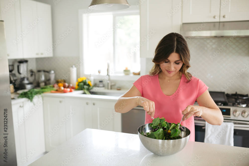 Woman making and tossing salad at home Woman making and tossing salad at home