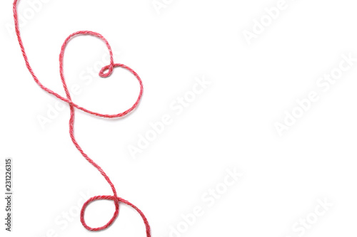Red thread and heart isolated on white background