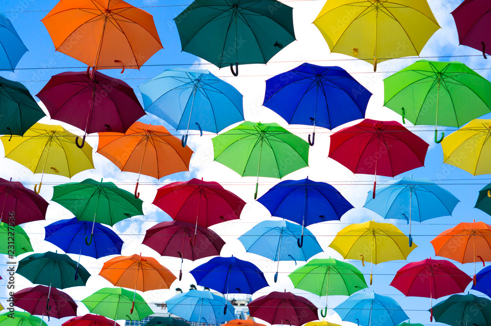 many bright umbrellas hanged between buildings