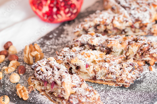 Puff pastry plait with chocolate cream, walnuts, hazelnuts and pomegranate seeds.
