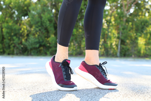 Sports woman in running shoes standing on toes , close-up view focused on the sneakers