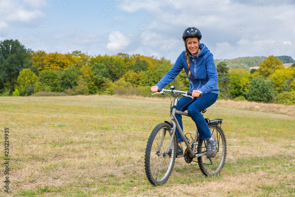 European woman cycling on mountain bike in nature