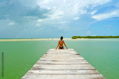 A girl sitting on a pier at Caribbean photo