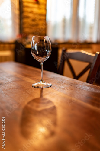 Bicchiere di vetro in una cantina, pronto per essere riempito di vino e per la degustazione, in luci morbide