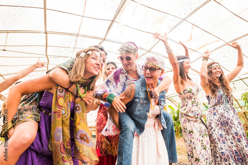 Group of crazy happy females with different ages having fun together in friendship forever. Hippy colored trendy clothes for beautiful ladies in outdoor celebration. A lot of laugh and smile concept