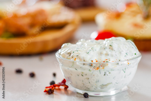Greek Tzatziki sauce in a sauce-boat on table