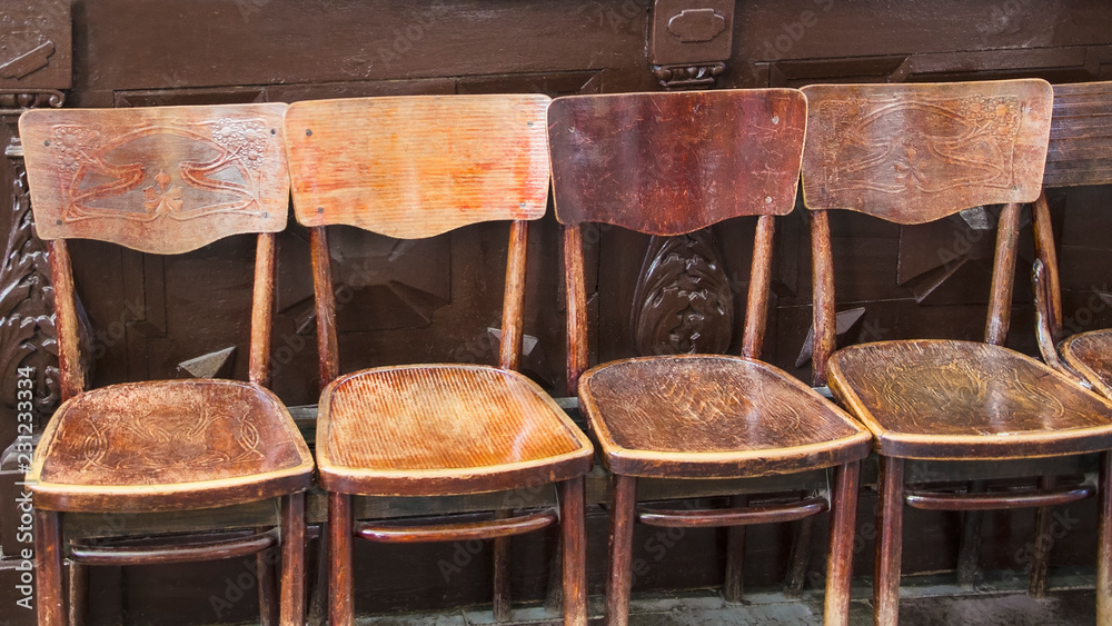 a row of brown old antique chairs in the temple for rest, prayers