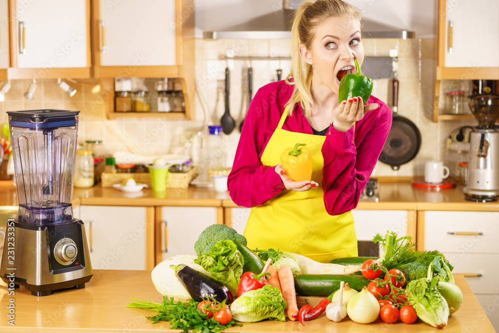 Funny woman taking bite of bell pepper Funny woman taking bite of bell pepper