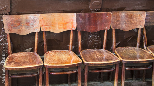 a row of brown old antique chairs in the temple for rest, prayers