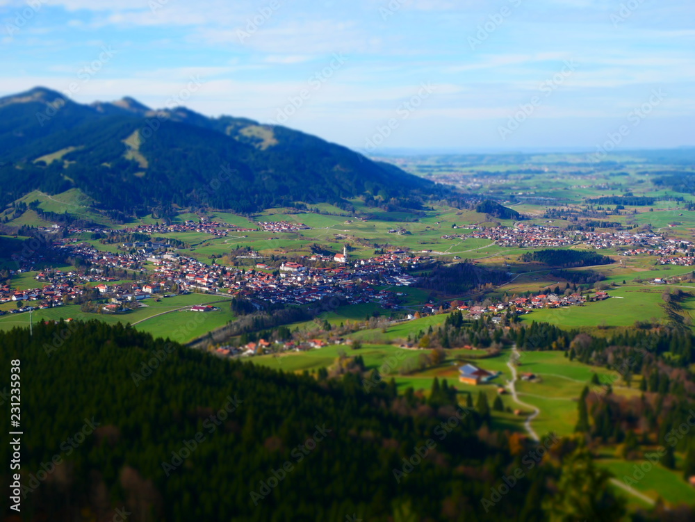 Tilt shift image of village in green mountain landscape